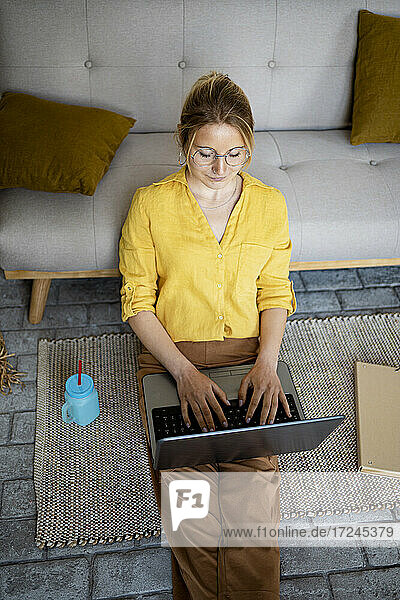 Geschäftsfrau  die zu Hause sitzend am Laptop arbeitet