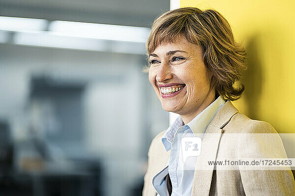 Mature female entrepreneur smiling while looking away