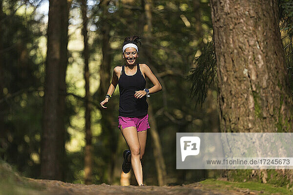 Happy woman running in forest