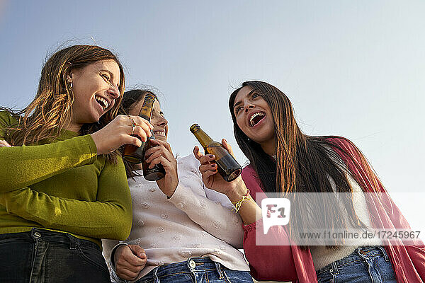 Happy female friends with beer enjoying together