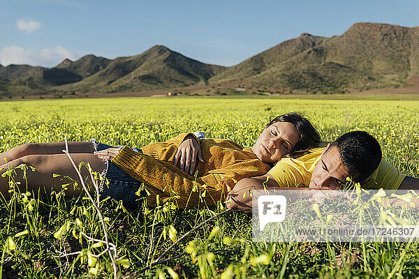Junges Paar im Gras liegend auf einer Wiese