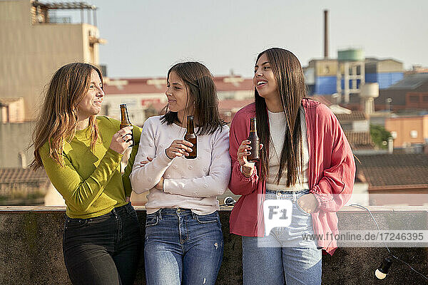 Female friends drinking beer on rooftop