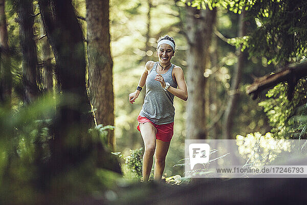 Excited woman running in forest