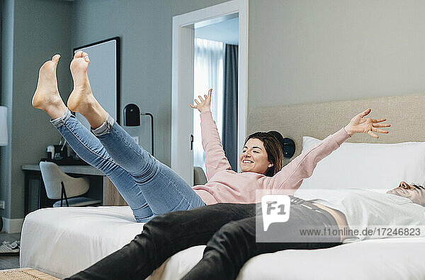 Glückliches Paar entspannt sich auf dem Bett im Hotelzimmer