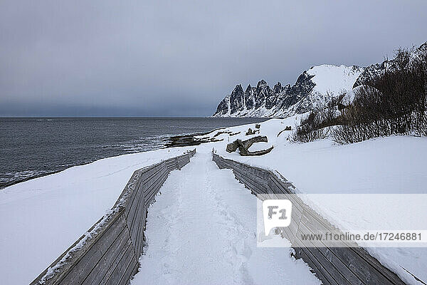 Norwegen  Tromso  Ersfjord  Verschneite Straße entlang der Meeresküste der Insel Senja