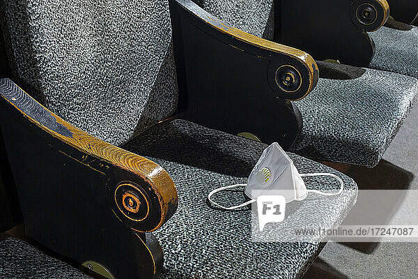 Gesichtsschutzmaske auf dem Sitz in einem leeren Theater
