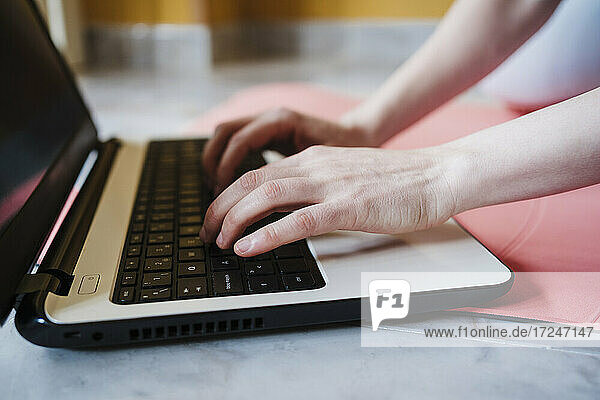 Female athlete typing on laptop at home
