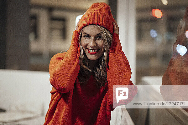 Smiling woman with knit hat at coffee shop