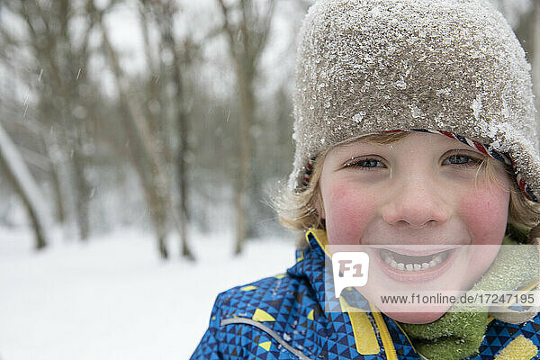 Cute boy freezing in snow during winter
