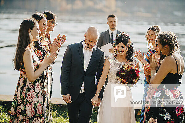 Hochzeitsgäste applaudieren dem Paar bei der Trauung