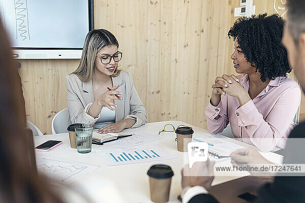 Unternehmerin diskutiert mit Kollegen bei einer Besprechung im Büro