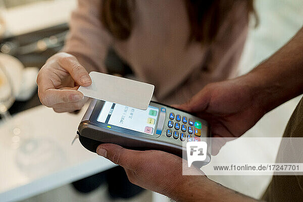 Frau bezahlt mit Kreditkarte im Restaurant