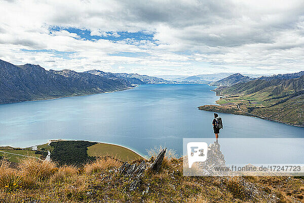 Neuseeland  Otago  Männlicher Wanderer bewundert den Blick auf den Hawea-See von einem Berggipfel aus
