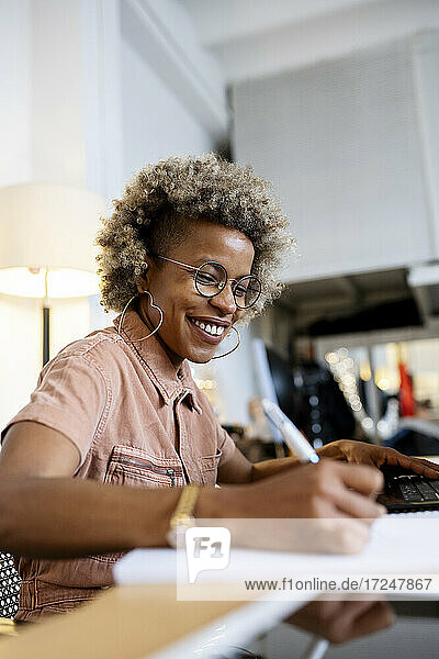 Lächelnde Geschäftsfrau bei der Arbeit im Heimbüro