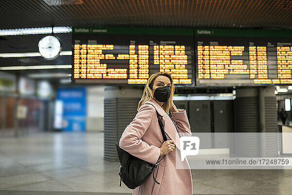 Mittlere erwachsene Frau mit Gesichtsschutzmaske auf einem Flughafen