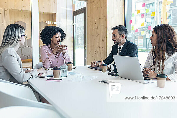 Multiethnische männliche und weibliche Fachleute diskutieren während einer Sitzung im Büro