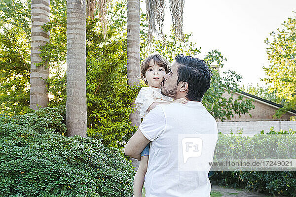 Vater küsst Sohn  während er im Hinterhof steht