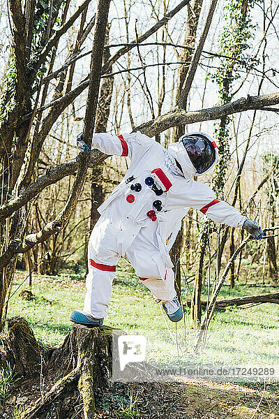 Astronautin hängt an einem Ast im Wald