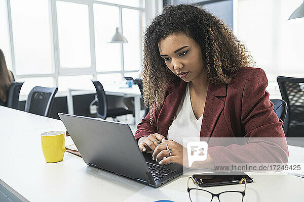 Geschäftsfrau arbeitet am Laptop am Schreibtisch im Büro