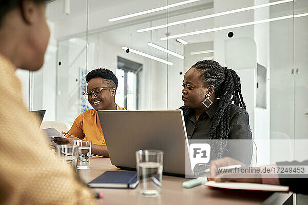 Unternehmerinnen sitzen während einer Besprechung in einem Coworking-Büro am Schreibtisch
