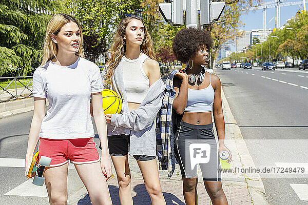Junge Frauen schauen weg  während sie auf dem Gehweg stehen