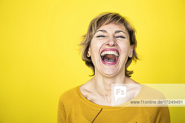 Frau lachend vor gelbem Hintergrund