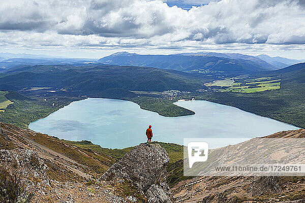 Neuseeland  Tasmanischer Bezirk  Männlicher Wanderer steht auf einer Felsformation mit Blick auf den malerischen Rotoiti-See