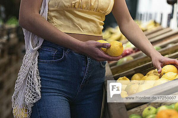 Frau hält Zitronen im Laden