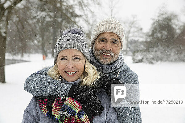 Senior man with arm around on woman at park during winter