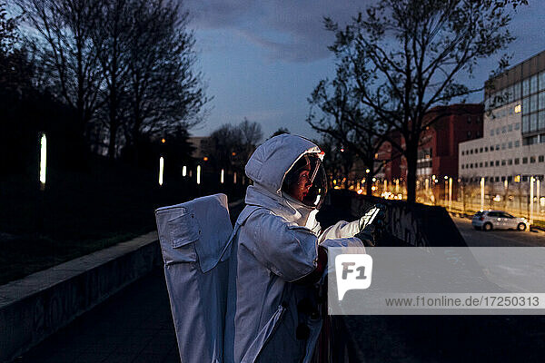 Weibliche Astronautin benutzt nachts in der Stadt ein Smartphone