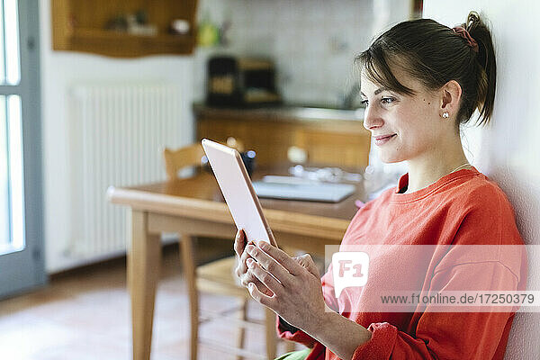 Schöne Frau benutzt digitales Tablet zu Hause
