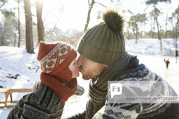 Boy kissing father during winter