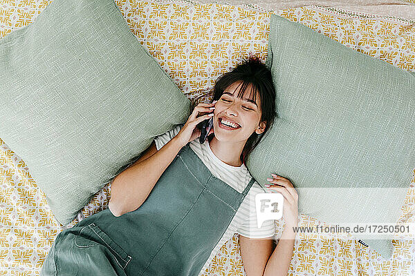 Schöne Frau  die mit ihrem Handy telefoniert und sich im Schlafzimmer ausruht