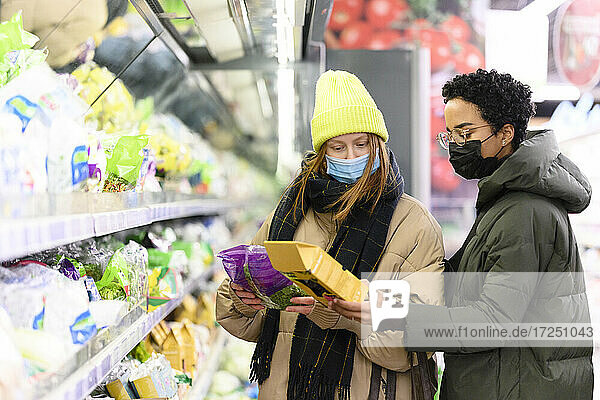Freundinnen beim Einkaufen im Supermarkt während COVID-19