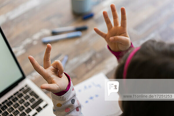 Girl counting fingers while studying at home