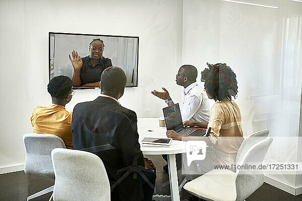 Male and female professionals discussing during video conference at coworking office