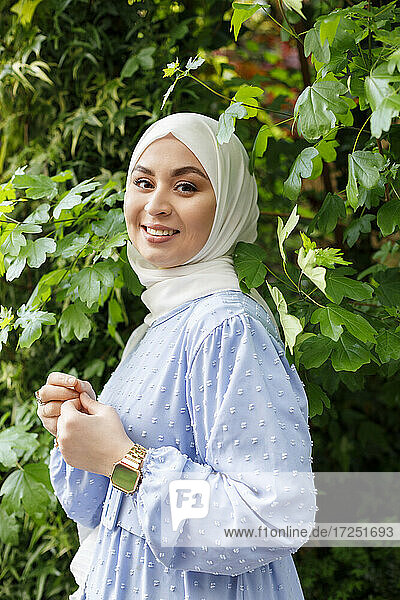 Young woman wearing hijab standing amidst leaves