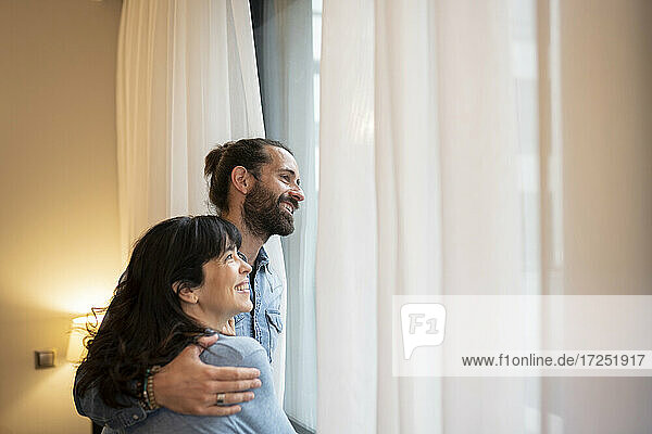 Glückliches Paar schaut in einer Hotelsuite weg