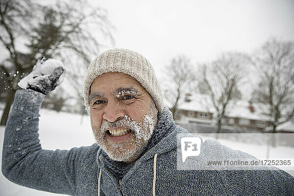 Mann wirft Schneeball im Freien