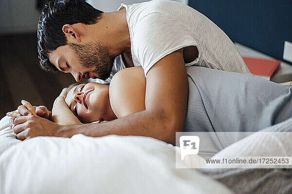 Affectionate young couple in bedroom at home