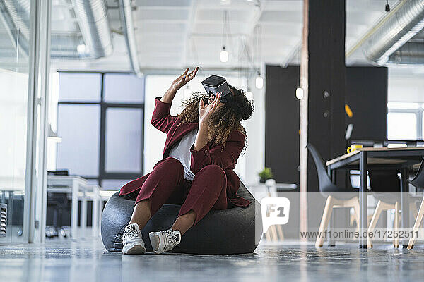 Businesswoman gesturing while using virtual reality simulator in office