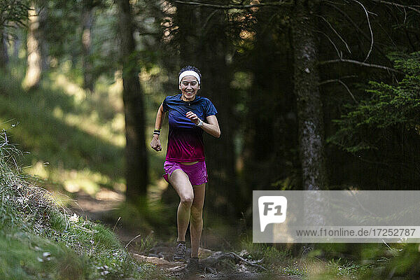 Weibliche Athletin läuft auf einem Waldweg