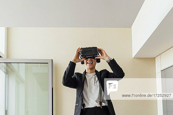 Happy businesswoman with virtual reality headset in office