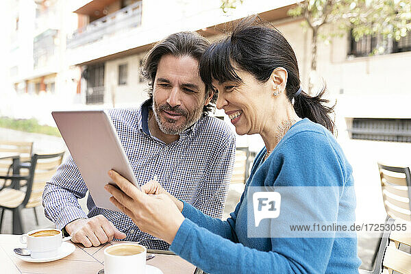 Man and woman using digital tablet at terrace