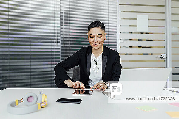 Junge Geschäftsfrau  die ein digitales Tablet bei der Arbeit im Büro benutzt