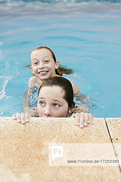 Geschwister spielen zusammen im Schwimmbad