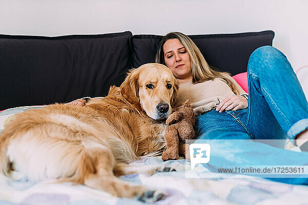 Italien  Junge Frau mit Hund entspannt auf dem Bett