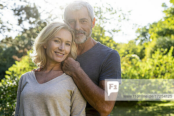 Portrait of smiling mature couple standing in backyard