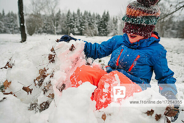 Kanada  Ontario  Junge spielt im Schnee
