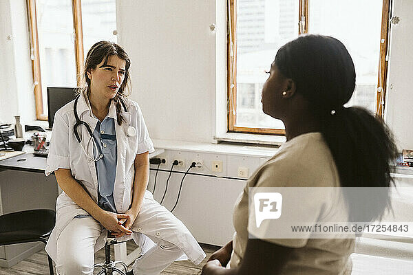 Weiblicher Arzt im Gespräch mit dem Patienten während der Beratung in der medizinischen Klinik